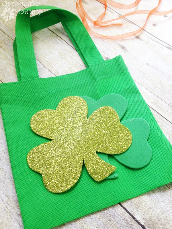 St. Patrick's Day Treat Bag: Are you planning on hosting a St. Patrick’s Day bash this year? If so, take a look at this easy and super inexpensive St. Patrick’s Day treat bag! You can make you own using just a few dollars worth of Dollar Tree supplies, and when finished you can stuff the bag with candy, gold coins, or whatever else you please. | Optimistic Mommy