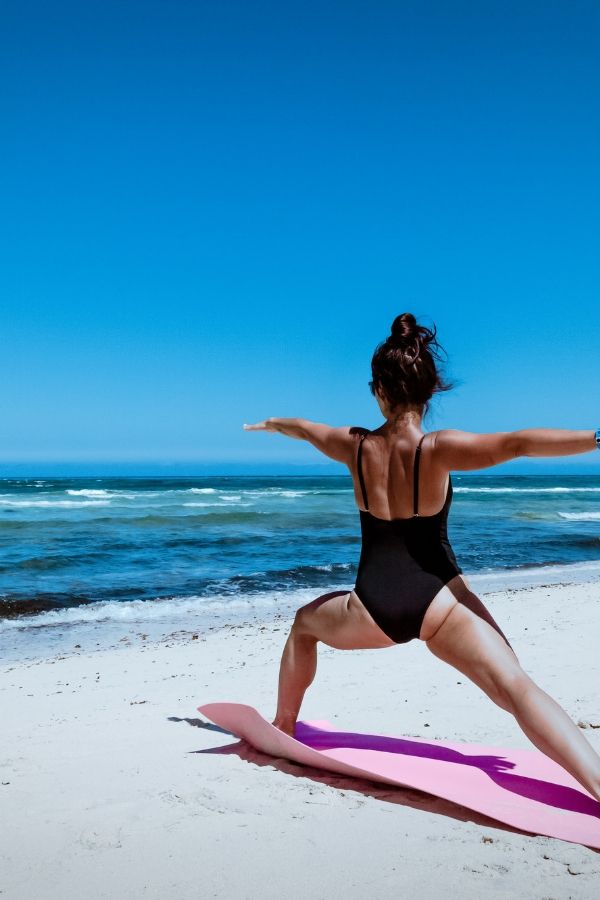 girl doing yoga on beach
