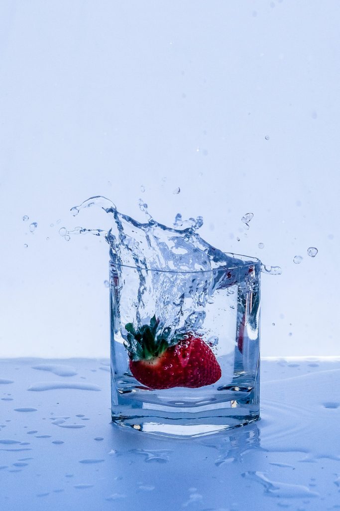 red strawberry in clear glass