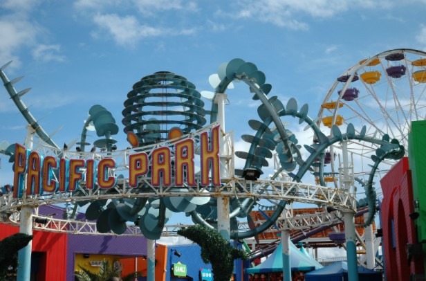 View of the Pacific Park sign, with several rides in the background