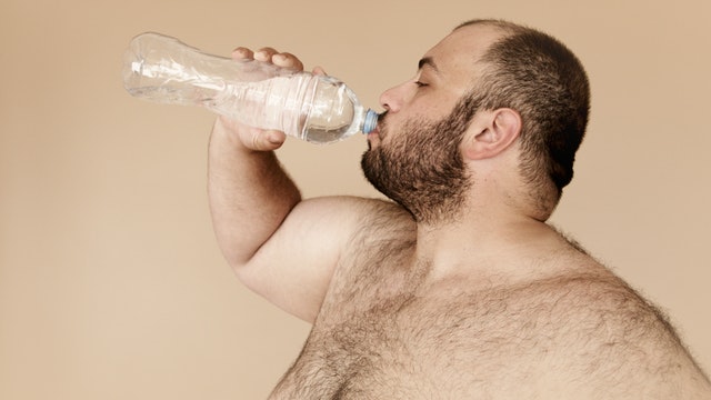 fat man drinking water