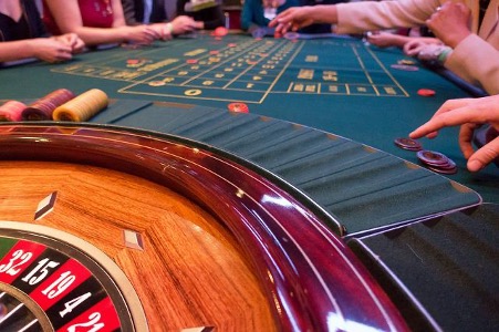 Players playing Roulette game in casino.