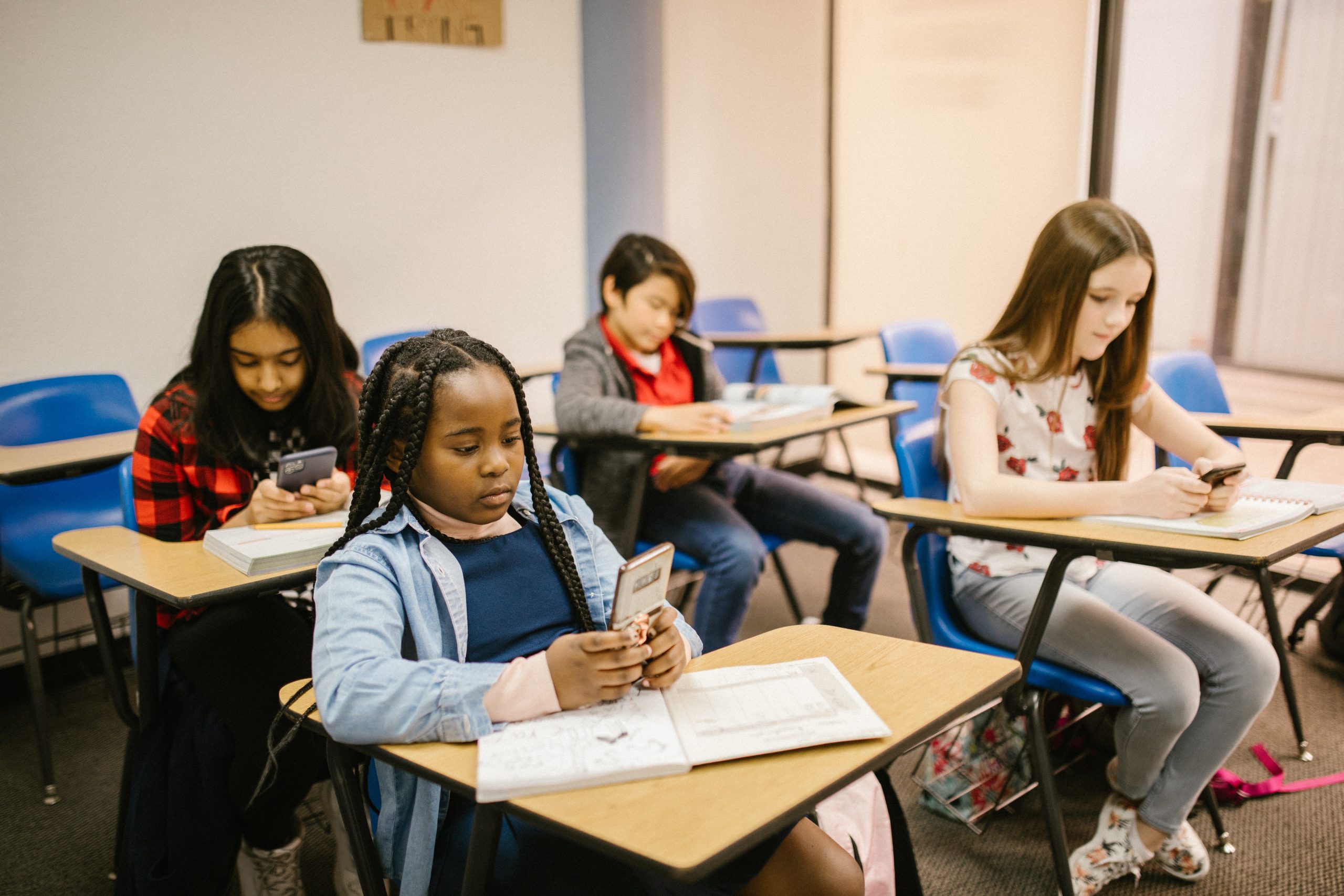 Kids with smartphones in a classroom.