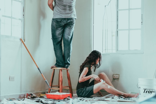 Man and woman painting their house.