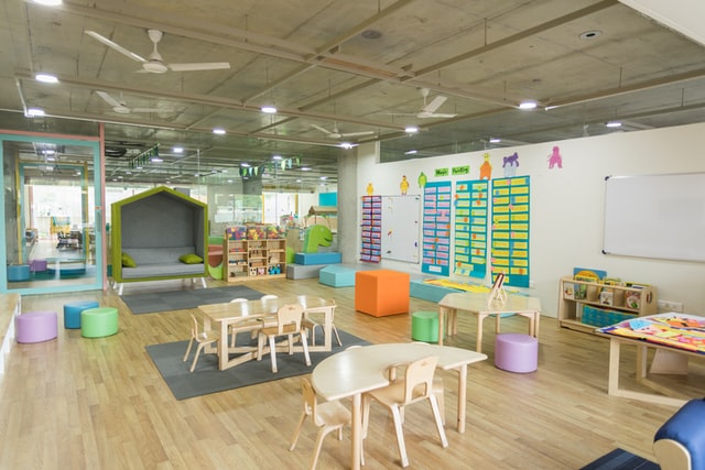 A vibrant daycare centre with wooden furniture, toys and play area for kids.