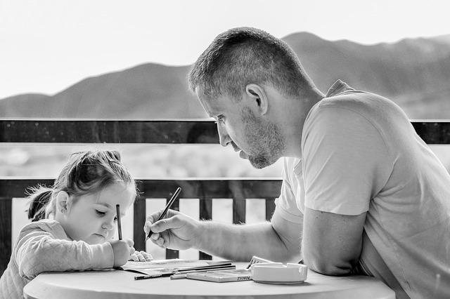 A father assists his daughter in her work.