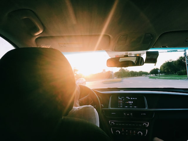 A teenager driving a car on the road.