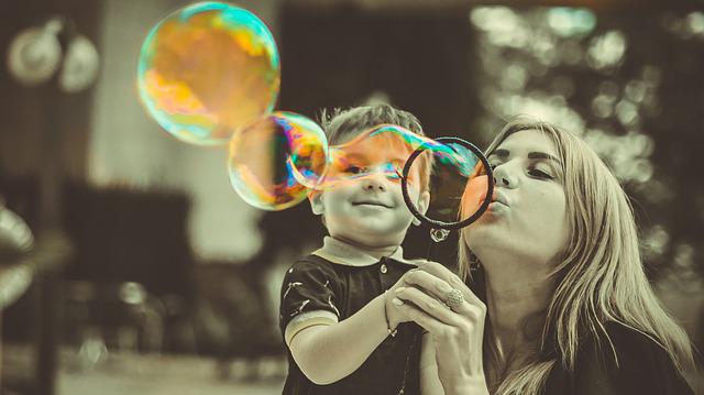 A woman making bubbles with her son.