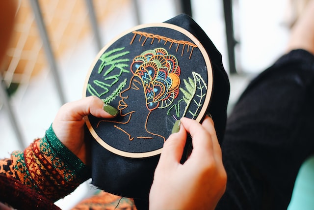 A woman making Embroidered Custom Patches.