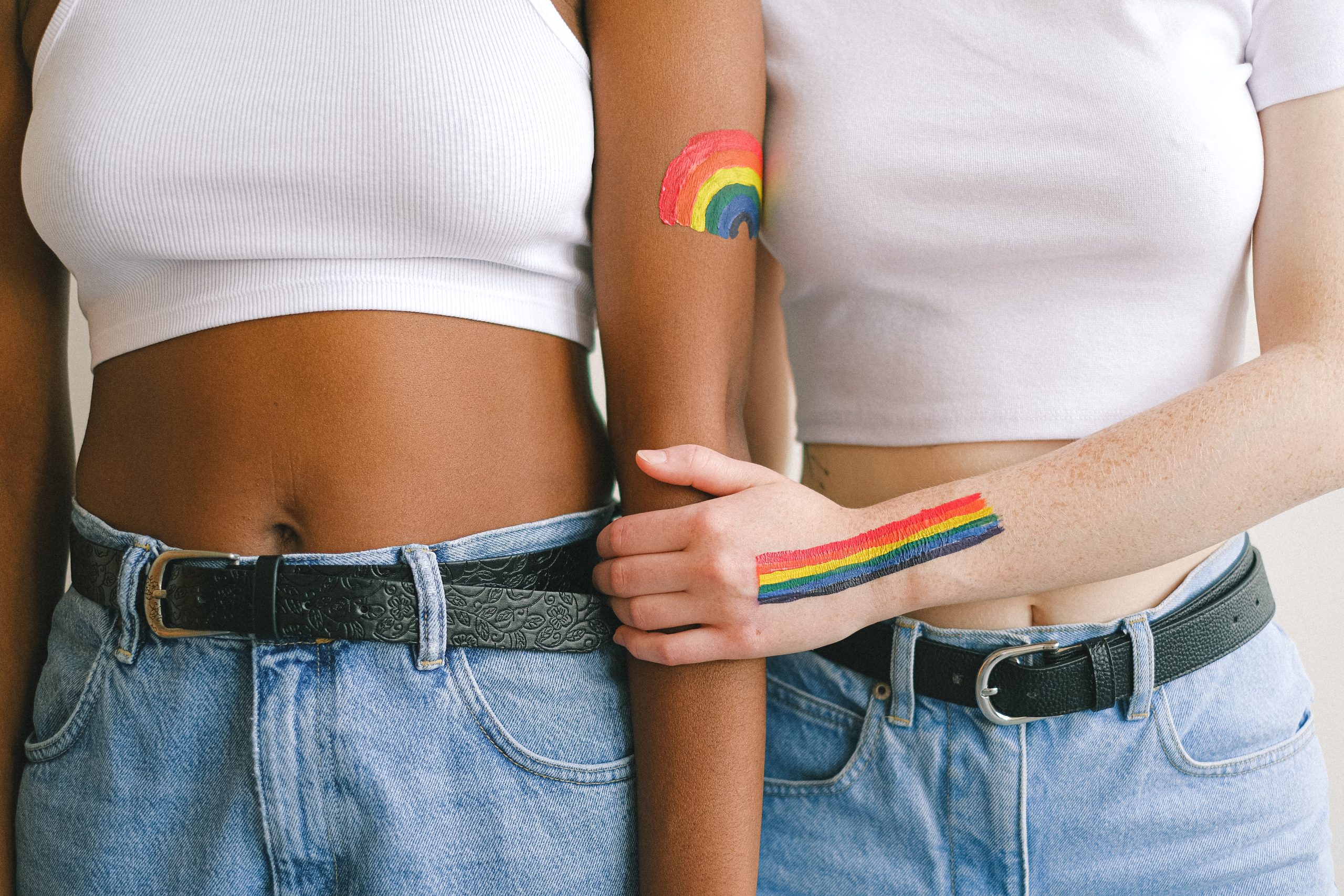 Two women stand hand in hand.