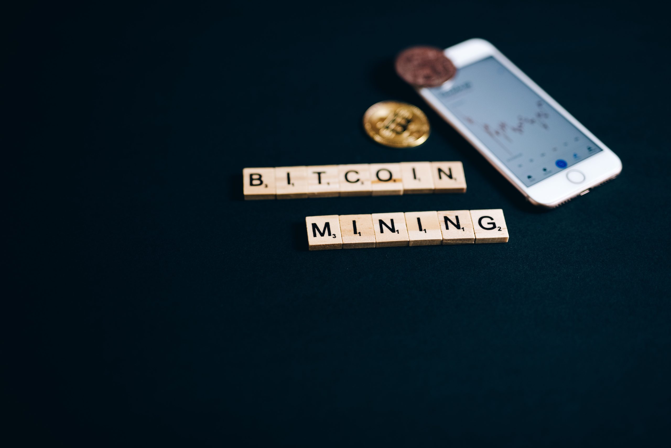 A phone, bitcoin, and a bitcoin mining nametag.