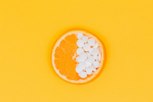 An orange with tablets on it.