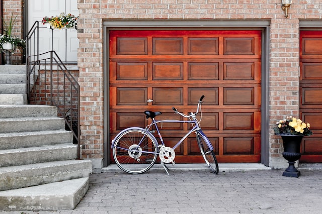 A cycle has been parked near the garage door.
