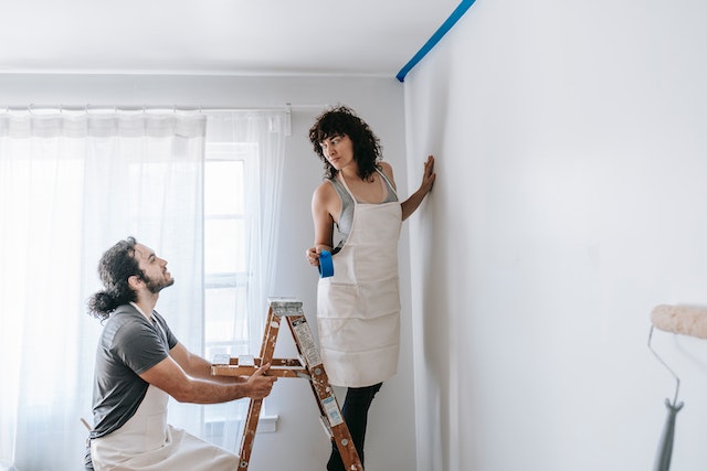 A man and a woman painting the house.