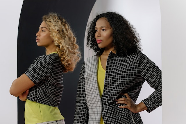 A woman wearing a blazer and yellow comfortable tee.