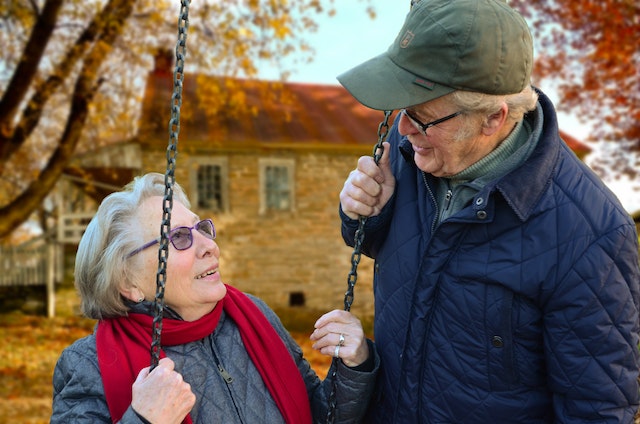 An old man and woman enjoying on the swing.