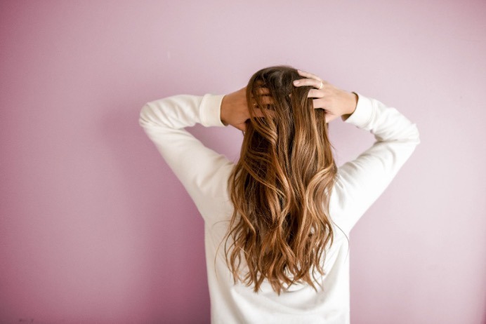 A woman rubbing her long hair.