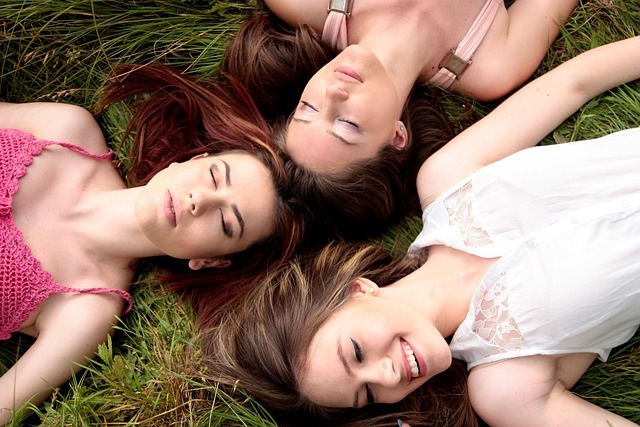 3 friends lying on the grass.