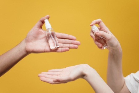 Women holding sanitizer bottles.